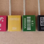 Photo des différents marquages laser réalisable sur des scellés à platine en aluminium anodisé (Logo, texte, code à barres, QR code). Marquage réalisé sur le laser de la société S.E.I Sarl